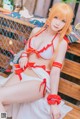 A woman in a red and white bikini sitting on a bench.