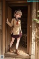 A girl in a school uniform standing in front of a door.