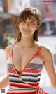 A woman in a red and white striped dress posing for a picture.