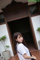 A woman standing in front of a door holding a black bag.