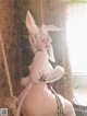 A woman in a bunny costume sitting on a swing.