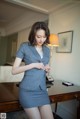 A woman in a business suit standing in front of a desk.